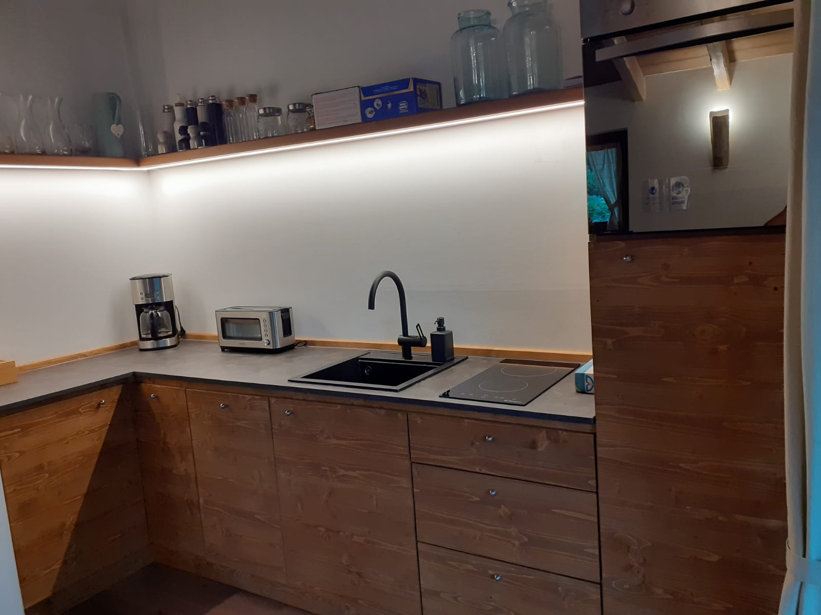 Dettaglio del progetto Cucina Moderna in Legno: Cucina su misura in legno con frigorifero ad incasso e piano di lavoro funzionale. - Immagine 1